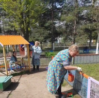 педагог красит забор.